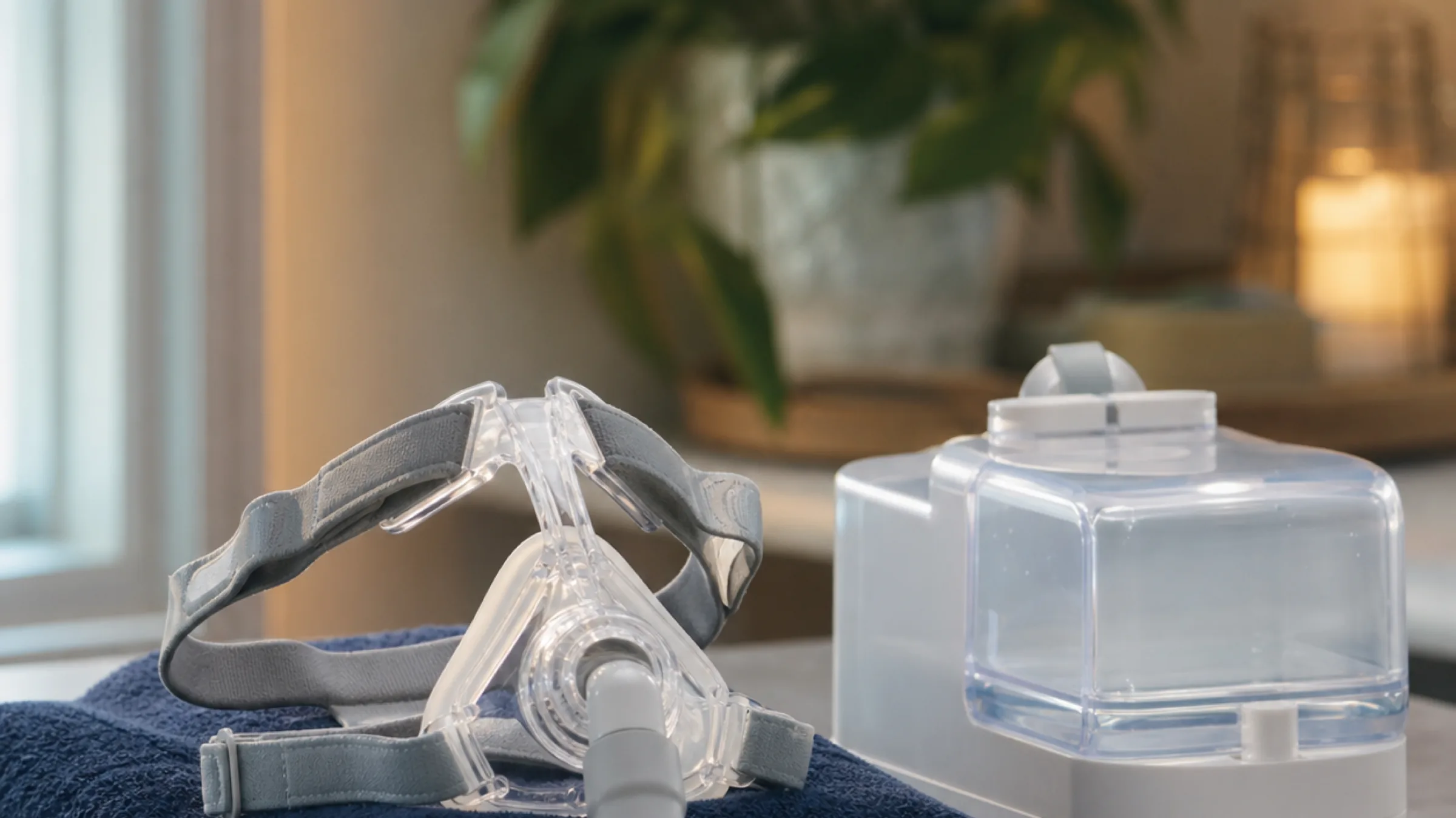 Full face CPAP mask beside a CPAP humidifier water chamber