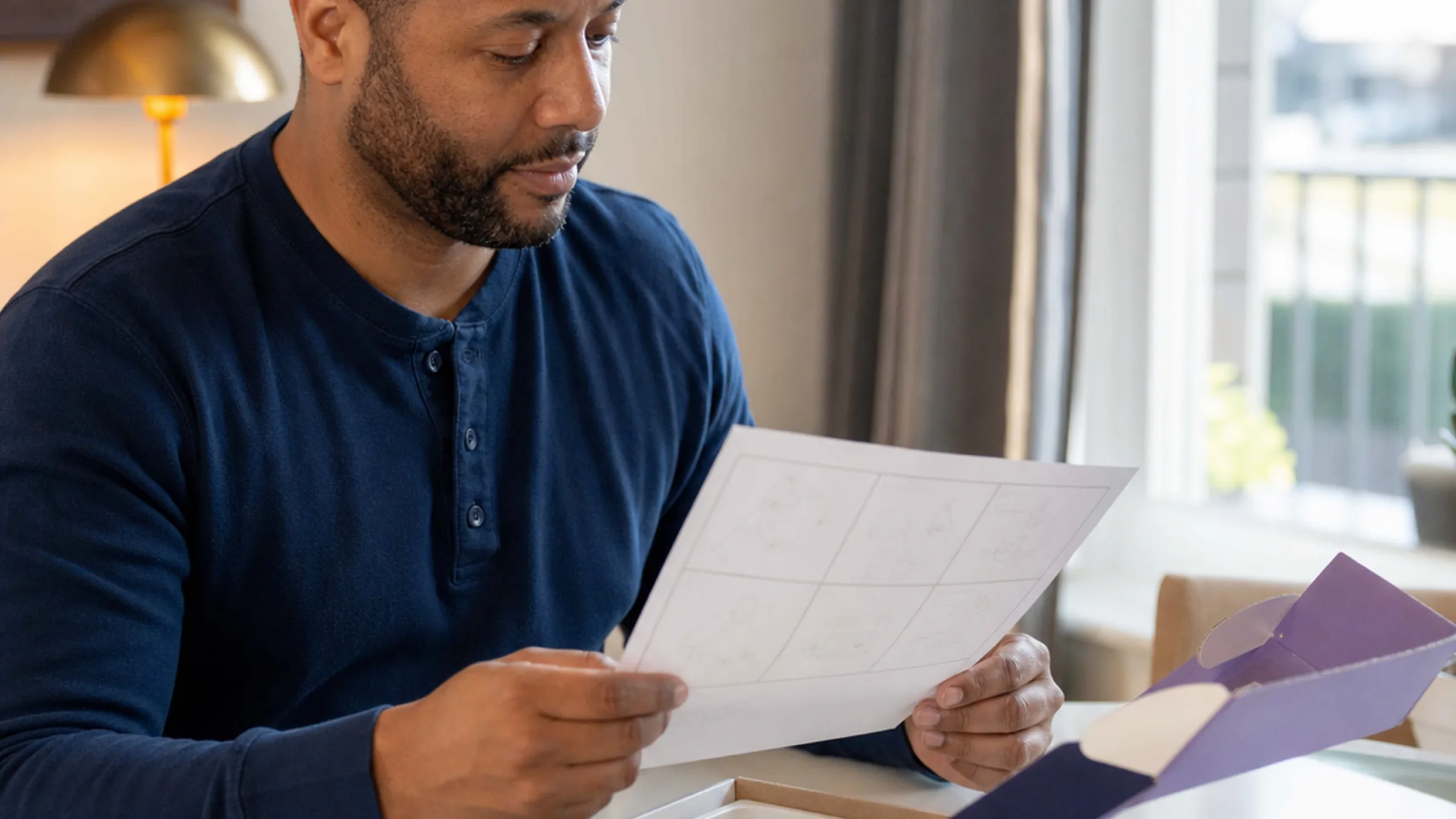 Man reading CPAP funding and insurance paperwork at home